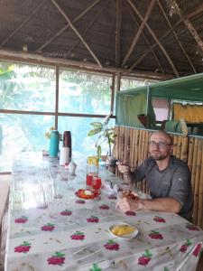a man sitting at a table with a plate of food at Amazon tucuxi in Mazán