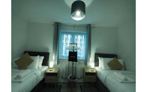 zwei Betten in einem Zimmer mit zwei Lampen und einem Fenster in der Unterkunft Barn Fold House with Parking, Garden, Wi-Fi in Telford + 12 Fotos