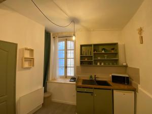 a kitchen with a sink and a window at Location studio rue du sauvage in Arles