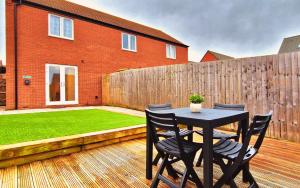 eine Terrasse mit einem Tisch und Stühlen auf einer Holzterrasse in der Unterkunft Barn Fold House with Parking, Garden, Wi-Fi in Telford