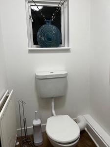 a bathroom with a toilet and a window with a fan at Modern studio in popular South Kensington location in London