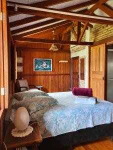 a bedroom with a large bed in a room with wooden walls at Encontro das Águas in Guarda do Embaú