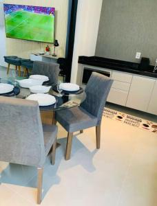 a dining room with a table and chairs and a tv at Apto alto padrao ao lado do IBIS - Av Esmeraldas in Marília