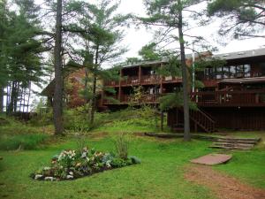 a house in the middle of a yard with flowers at Westwind Inn on the Lake in Buckhorn