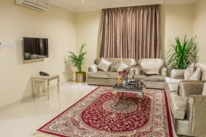 a living room with two couches and a rug at Al Masem Luxury Hotel Suite 5 in Al Hofuf