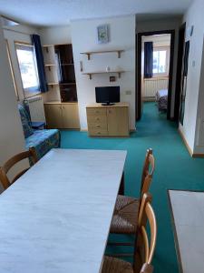 a room with a table and chairs and a television at Mountain View in Passo del Tonale