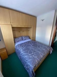 a small bedroom with a bed with a wooden headboard at Mountain View in Passo del Tonale