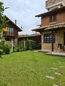 a house with a lawn in front of it at Encontro das Águas in Guarda do Embaú