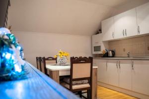 a kitchen and a table with a vase of flowers on it at Apartman KIKI in Kupres