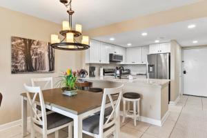 Una cocina y un comedor con mesa y sillas. en Unit 3306 - Ocean & Racquet Resort, en St. Augustine Beach