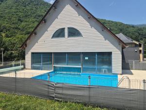 a house with a swimming pool in front of it at Duplex 55m2, 6 personnes, chiens acceptés in Arreau