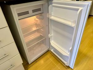 an empty refrigerator with its door open in a kitchen at Flat Esplêndido na Asa Sul in Brasilia