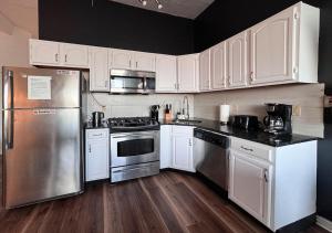 a kitchen with white cabinets and stainless steel appliances at See NY Now Sleeps 21 in Union City