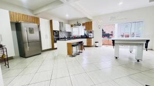 een grote keuken met een koelkast en een tafel bij Martin de Sá-200 metros da praia in Caraguatatuba