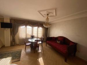 a living room with a red couch and a table at Pyramid view! Sleeps 13 in Cairo