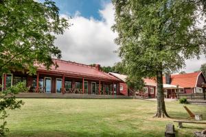 an exterior view of a red building with a tree at Åkulla Outdoor Resort in Rolfstorp