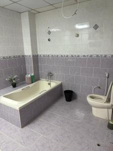 a bathroom with a bath tub and a toilet at Four Stars Residence in Dubai