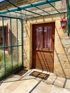 a building with a wooden door and a window at Maison d'Antan - PiscineJardinClim - Bourg de Cuzance in Cuzance +43 photos