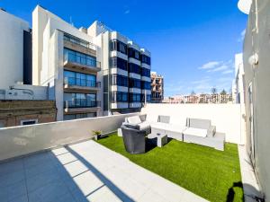 a balcony of a building with a bench and grass at St Julians Penthouse in Paceville