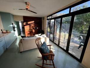 ein Wohnzimmer mit einem Sofa und einem Stuhl vor den Fenstern in der Unterkunft Scarbados Eco 1 Bed Seaside Cottage in Scarborough