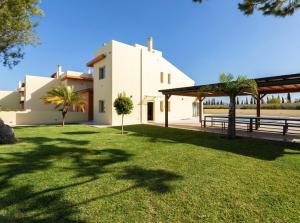 una grande casa bianca con un cortile erboso di Stunning Villa with Heated Pool, Garden, BBQ a Quarteira