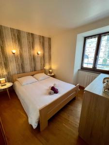 a bedroom with a bed with a stuffed animal on it at Casa Trinita -T3 -Centre Sainte-Féréole in Sainte-Féréole
