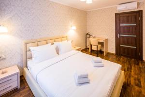 a bedroom with a large white bed with two towels on it at OK Apartments Lviv in Lviv