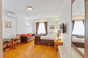 a hotel room with two beds and a couch at Vila Romantika in Zlatibor +31 photos