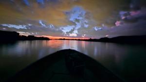 a boat on a lake with a sunset at La poderosa delta tigre in Tigre +15 photos