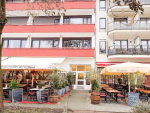 a building with tables and chairs in front of it at RheinmeetsMosel Rheinufer Deutsches Eck in Koblenz
