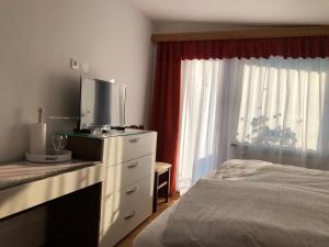 a bedroom with a bed and a dresser with a tv on it at Sobe apartma Dobe in Bled