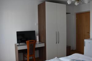 a bedroom with a desk with a tv and a chair at Sobe apartma Dobe in Bled