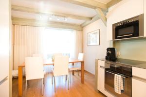 eine Küche und ein Esszimmer mit einem Tisch und Stühlen in der Unterkunft Bernerhof Residence in Grindelwald