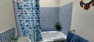 y baño con bañera y cortina de ducha de azulejos azules. en Cosy Cottage for two in the centre of Sedbergh, en Sedbergh 22 fotos más
