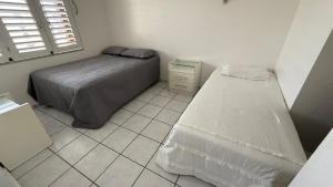 una camera con 2 letti e un pavimento piastrellato di Casa Maragogi - Barra Grande a Maragogi