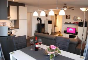 a kitchen and a living room with a table with wine glasses at Meeresrauschen 6 in Großenbrode