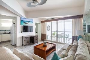 アカプルコにあるGreat BeachFront Condo,11th Floor, Great View!の大きなソファとテーブルのあるリビングルーム