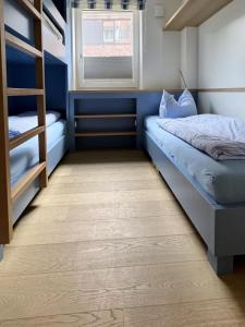 a bedroom with two bunk beds and a window at Stranddüne im Achterhus in Juist