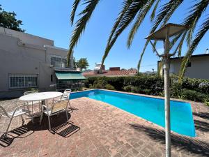 a patio with a table and chairs next to a swimming pool at Casa Privada Centro con Piscina a cinco cuadras del balneario las Hoyas Villa Carlos Paz in Villa Carlos Paz +18 photos
