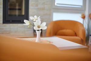 a white vase with white flowers on a table at Strandvilla Baabe 20 ABENDROT in Baabe