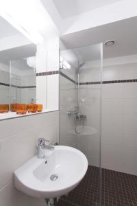 a white bathroom with a sink and a shower at Strandvilla Baabe 20 ABENDROT in Baabe +13 photos