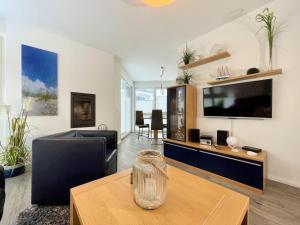 ein Wohnzimmer mit Fernseher und Tisch in der Unterkunft Strandvilla Baabe 10 HERZMUSCHEL in Baabe