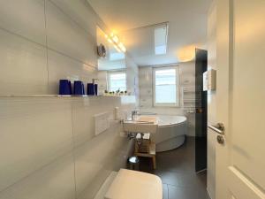 ein weißes Badezimmer mit Waschbecken und Toilette in der Unterkunft Strandvilla Baabe 10 HERZMUSCHEL in Baabe + 22 Fotos