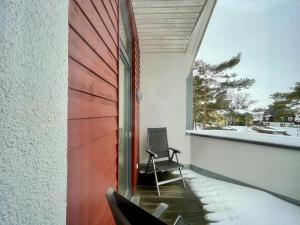 einen Stuhl auf dem Balkon eines Hauses in der Unterkunft Strandvilla Baabe 10 HERZMUSCHEL in Baabe