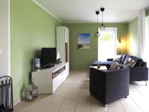 a living room with a couch and a tv at Kirschgarten 2 - Möwennest in Kellenhusen