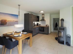 a kitchen and dining room with a wooden table and chairs at Kirschgarten 2 - Möwennest in Kellenhusen