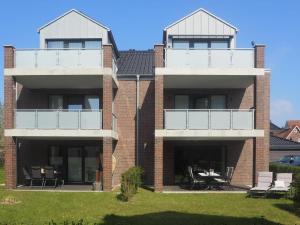 a brick building with two balconies and a patio at Kirschgarten 2 - Möwennest in Kellenhusen