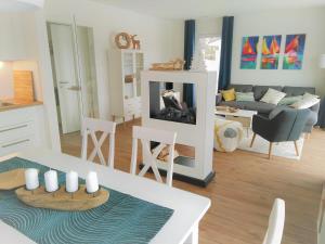 una sala de estar con una mesa y una chimenea en Sonnenweg 17, en Diemelsee