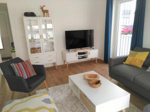 Una sala de estar con un sofá y un televisor. en Sonnenweg 17, en Diemelsee