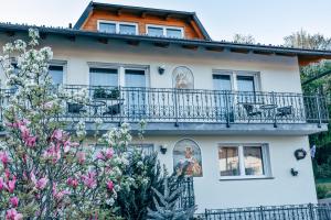 a house with a balcony and flowers at Sobe apartma Milena in Bled